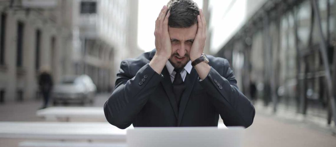 man-in-black-suit-covering-his-face-with-two-hands-3778964