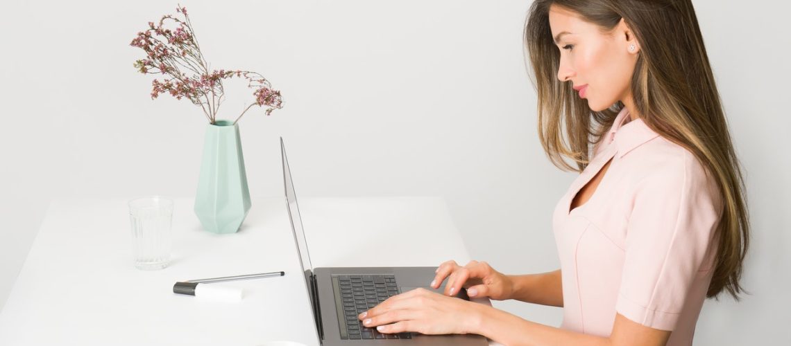 woman-in-pink-dress-using-laptop-computer-1586973