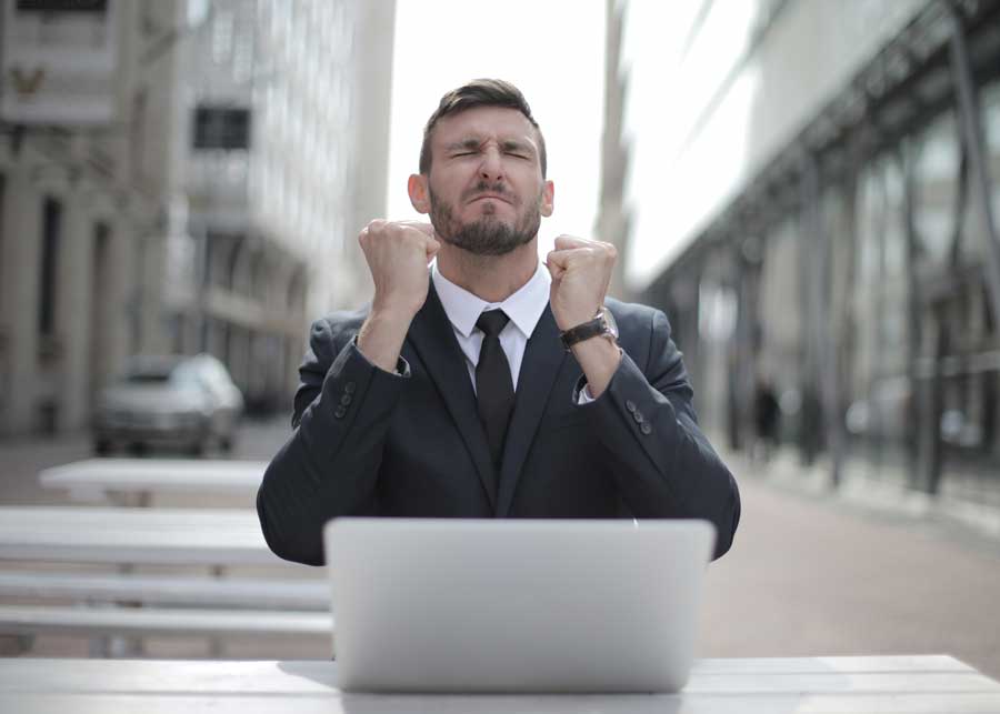 man-in-black-suit-sitting-on-chair-beside-buildings-3778966